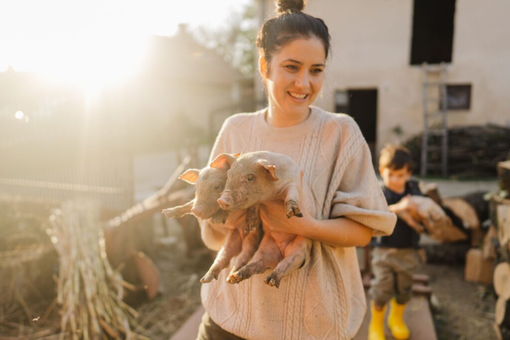 lady holding two piglets.